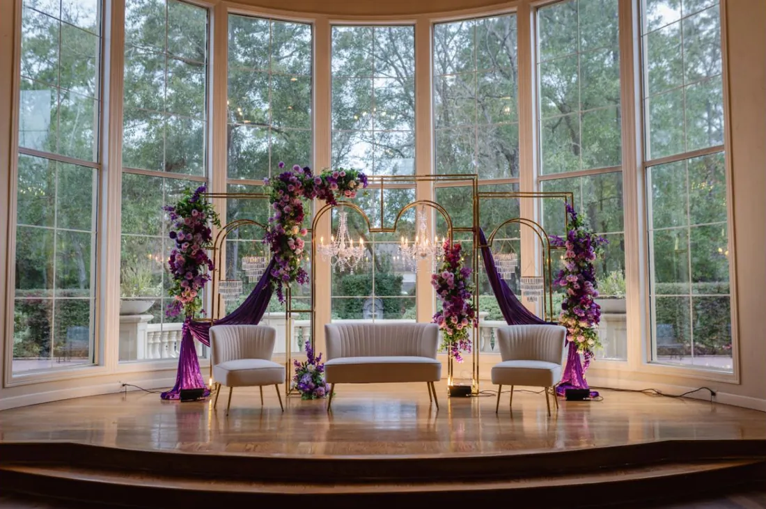 Violet and gold mandap set in a bay-window conservatory